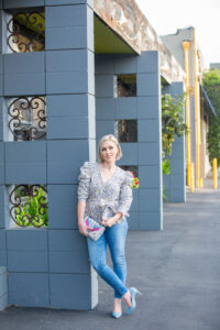 Personal Stylist Jaquelyn Wahidi wears a statement top with jeans and blue pumps.