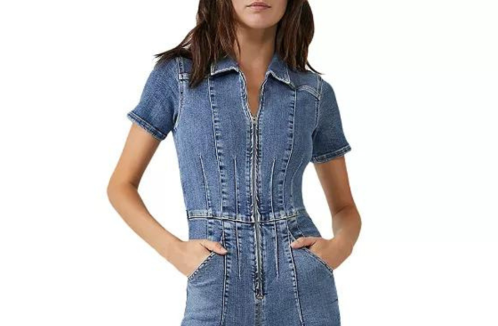 Model wears a blue denim jumpsuit against a white background