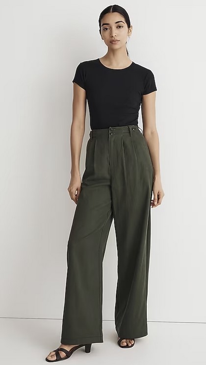 Model wears Madewell Wide Leg Pants in an olive color with a black tee and black heeled sandals