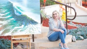 Personal Stylist Jaquelyn Wahidi wears a statement top in front of a painting in Solana Beach.